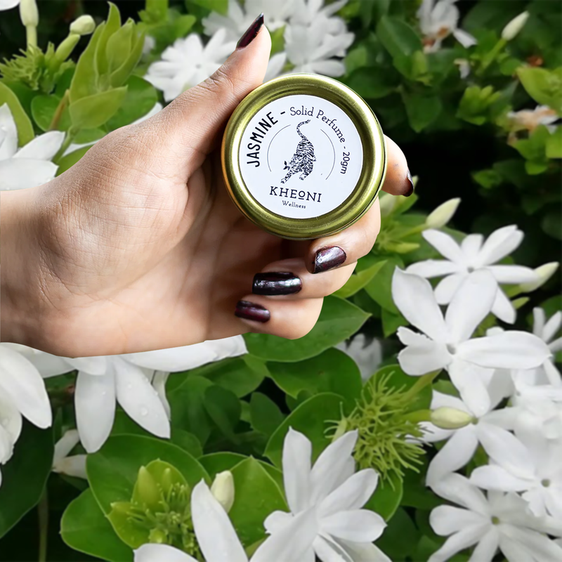 a girl is holding jasmine perfume in her hand